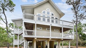 Een tweelaags huis met een balkon, een overdekte veranda en een garage.