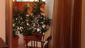 A room with a view of the sea through a window, a wooden chair, and a potted plant. - Hotel Club Ravezzo (Ugento)