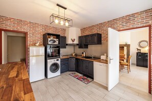 A compact kitchen with a washing machine, a microwave, and a sink.
