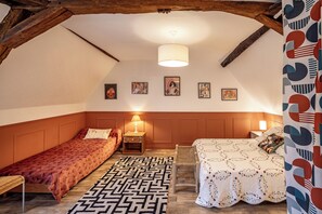 Une chambre avec deux lits, un tapis à motifs et des œuvres d’art murales.