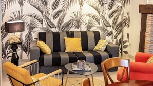 Ett vardagsrum med en soffa, fåtöljer, ett soffbord och en lampa.
