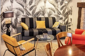 A living room with a sofa, armchairs, a coffee table, and a lamp.