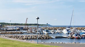 A marina with boats docked, a rocky breakwater, and a clear sky. - Amazing home in Borrby with WiFi (Borrby)
