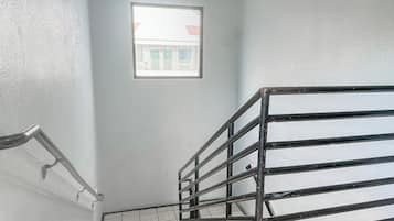 Una scala con ringhiera in metallo e una finestra che si affaccia su edifici.