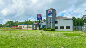 A hotel with a Relax Inn sign, a Weekly $100 rate sign, and a Low Rates sign.