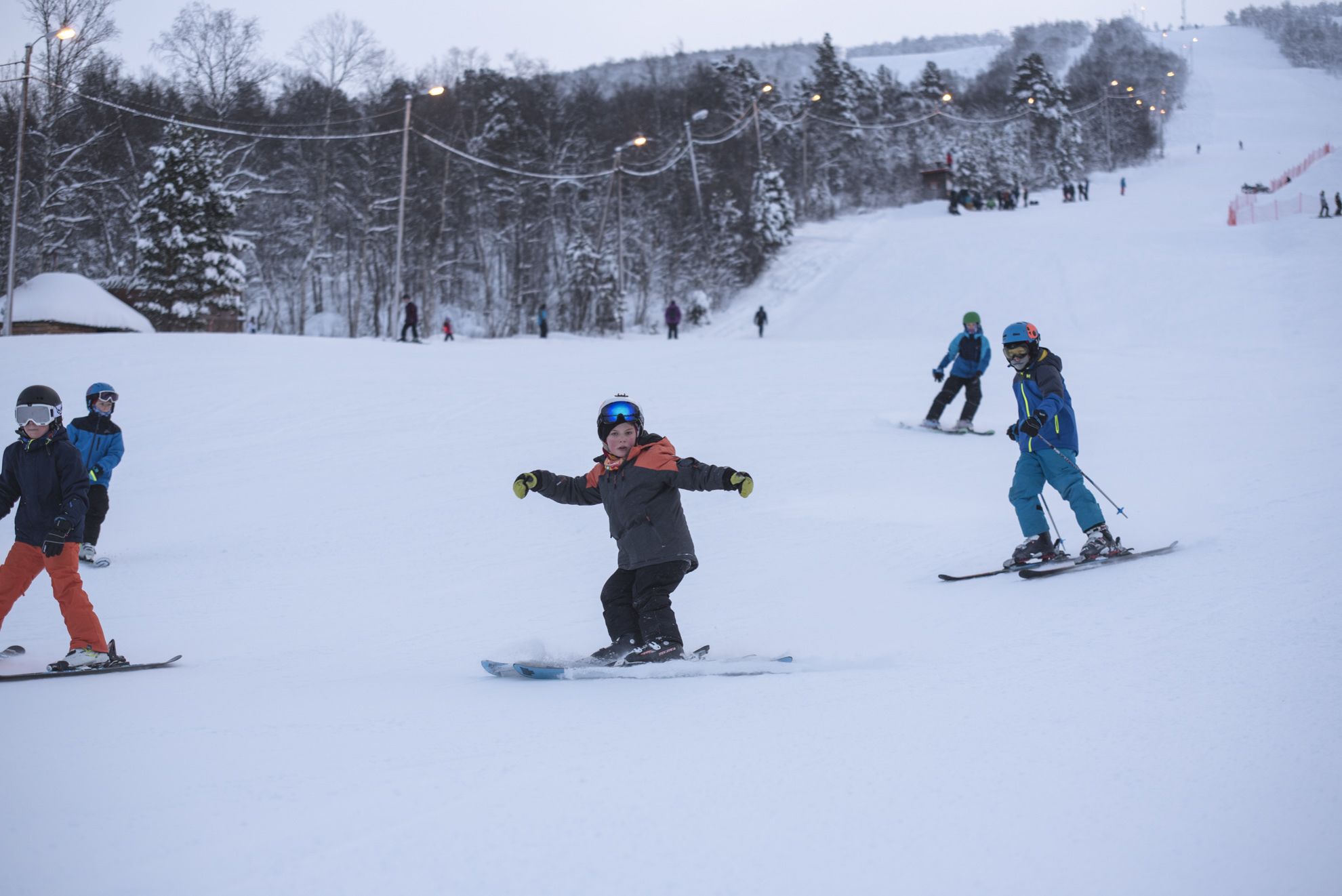 A ski slope with skiers and snowboarders.