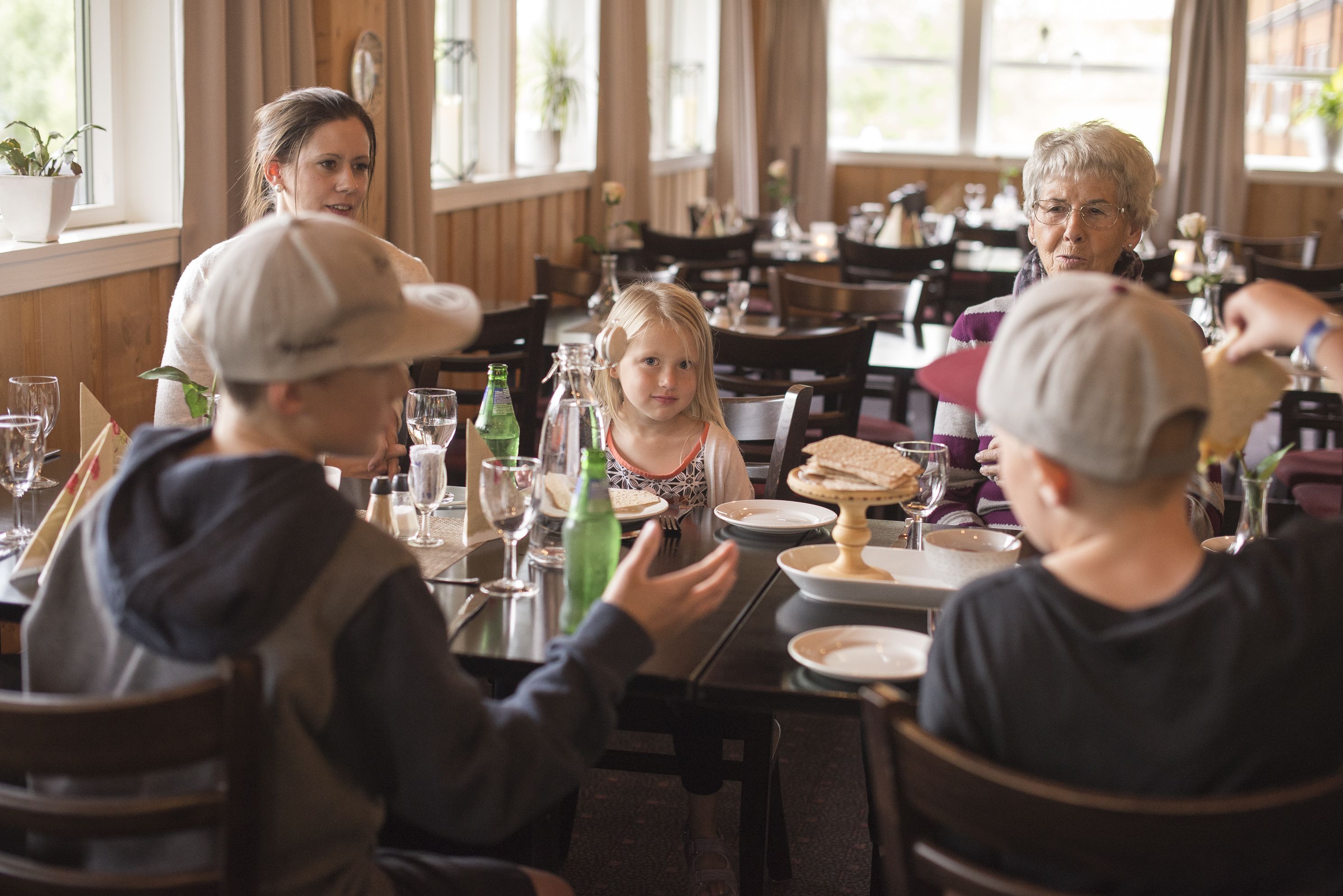 A family dining at a restaurant with wooden interiors and large windows.
