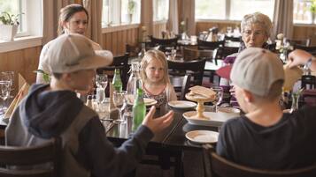 A family dining at a restaurant with wooden interiors and large windows.