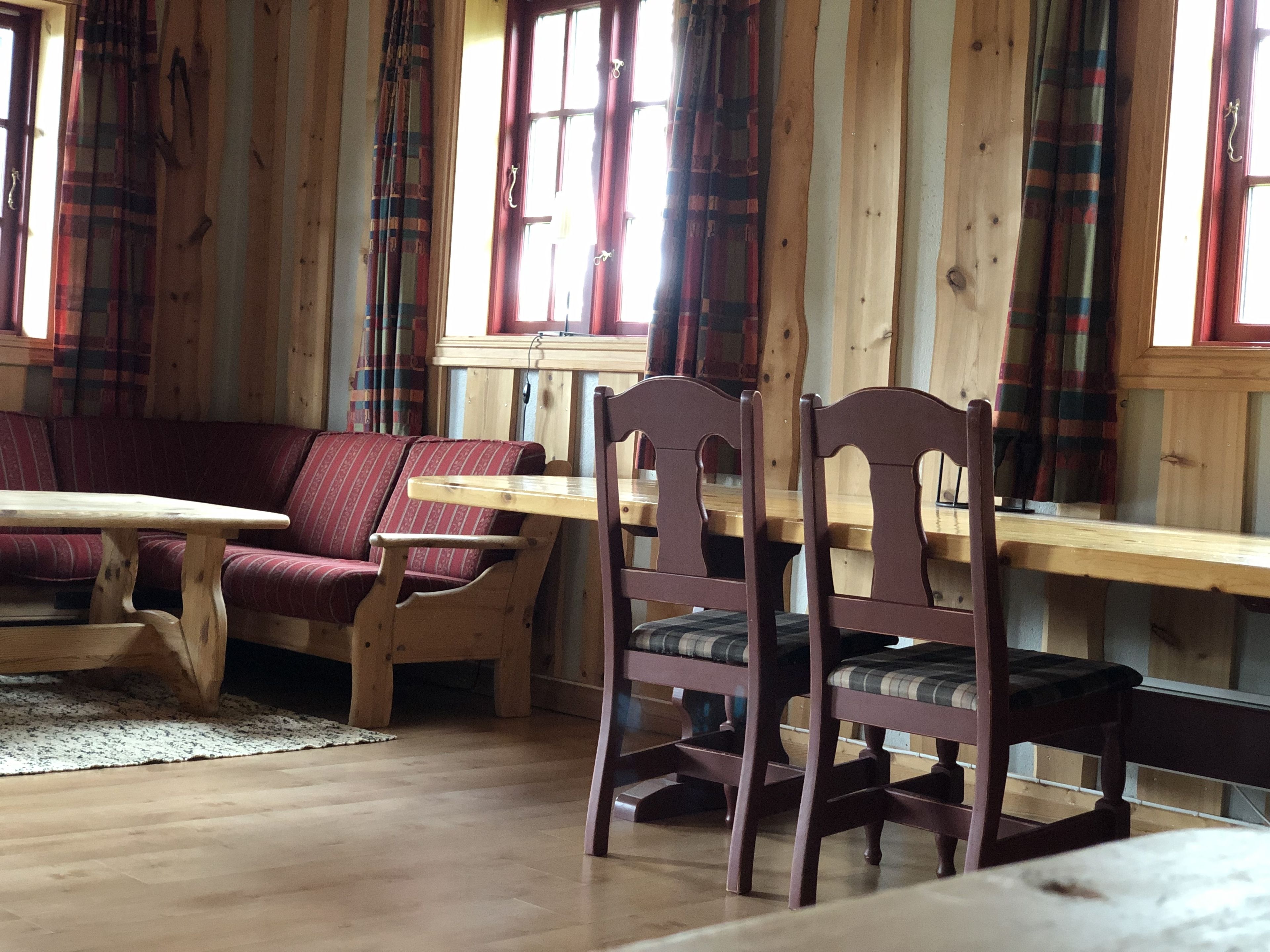 Un intérieur en bois avec un canapé, une table et des chaises.