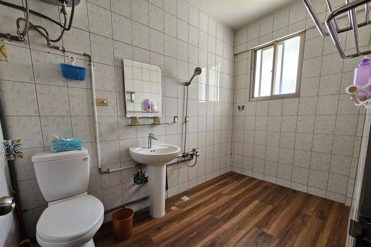 Une salle de bain avec des toilettes, un lavabo et une douche.
