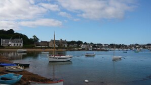 A harbor with several boats docked along the shore, surrounded by houses and a large building. - Country house 5 kms from the sea, 12 kms from Perros Guirec.  (Trelevern)