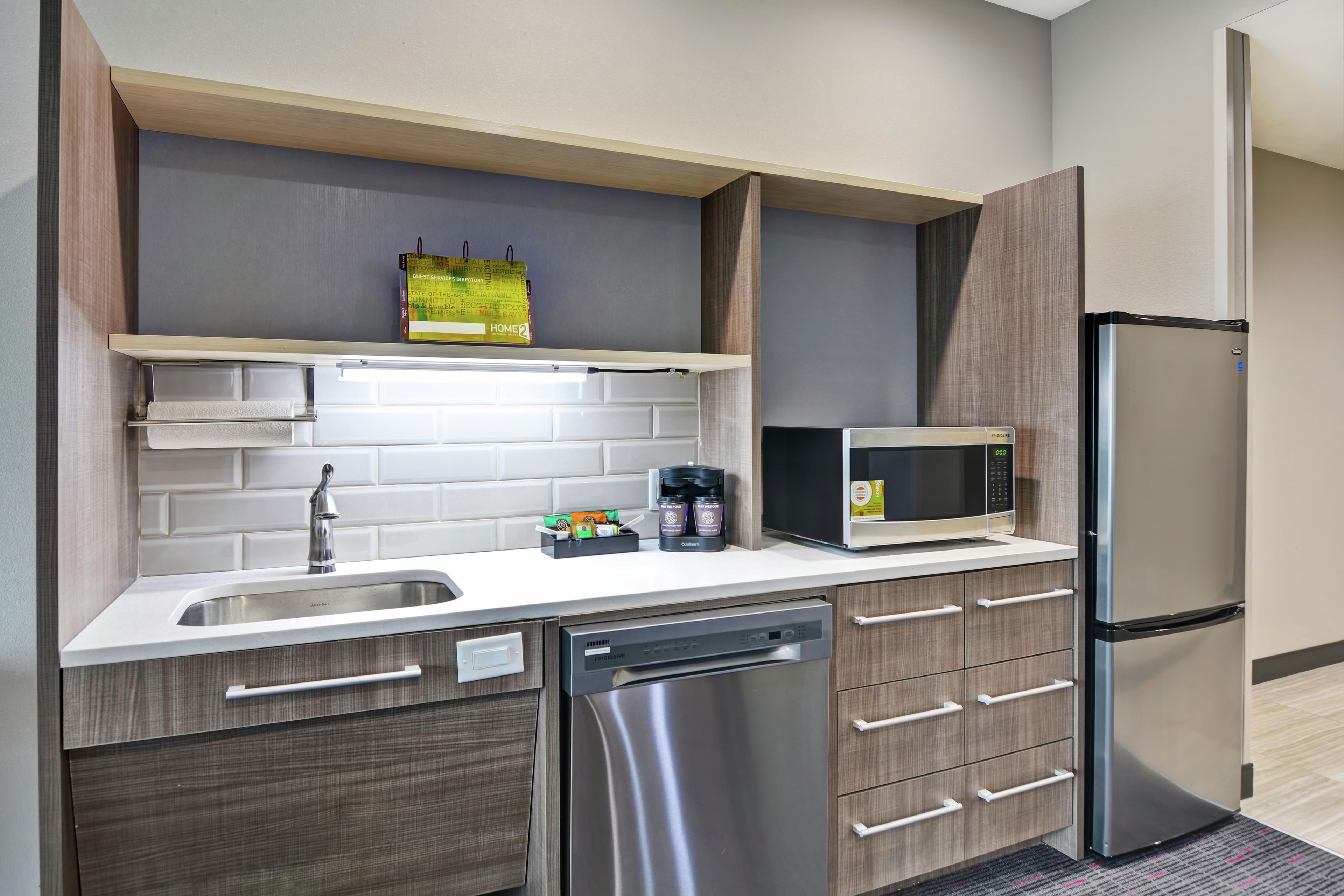 Una cocina compacta equipada con lavavajillas, microondas y refrigerador.