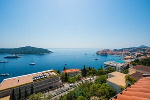 A coastal cityscape with a marina, buildings, and a hilly backdrop. - Apartments Horizon (Dubrovnik)