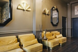 A waiting area with a row of yellow sofas and a small table with a decorative item.