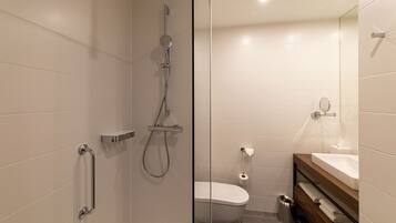 A modern bathroom with a shower, toilet, and sink.