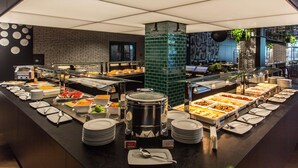 Ein Buffet mit verschiedenen Speisenstationen, einer Kaffeemaschine und einem großen zentralen Topf.