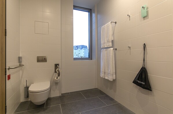 Un baño moderno con inodoro, bidé y toallero.