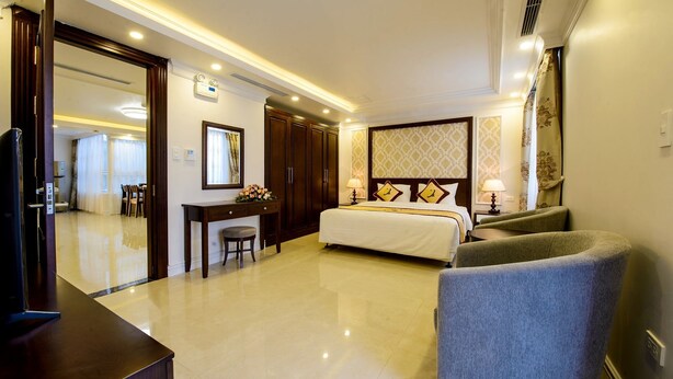 A hotel room with a bed, a desk, a chair, and a television. - The Shine Office and Apartment (Hai Phong)