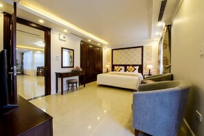 Une chambre d’hôtel équipée d’un lit, d’un bureau, d’une chaise et d’un téléviseur.