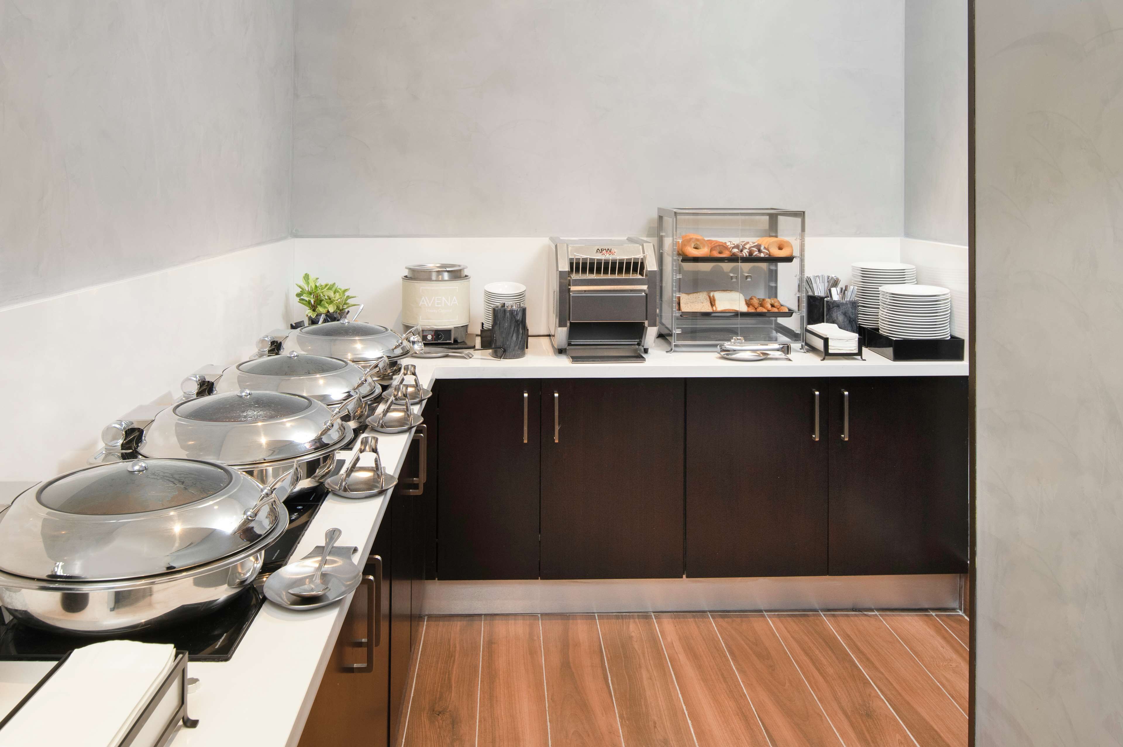 A buffet setup with multiple serving stations, including hot and cold food options, and a coffee machine.