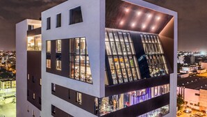 Un edificio moderno de varios pisos con amplios ventanales y un diseño arquitectónico distintivo.