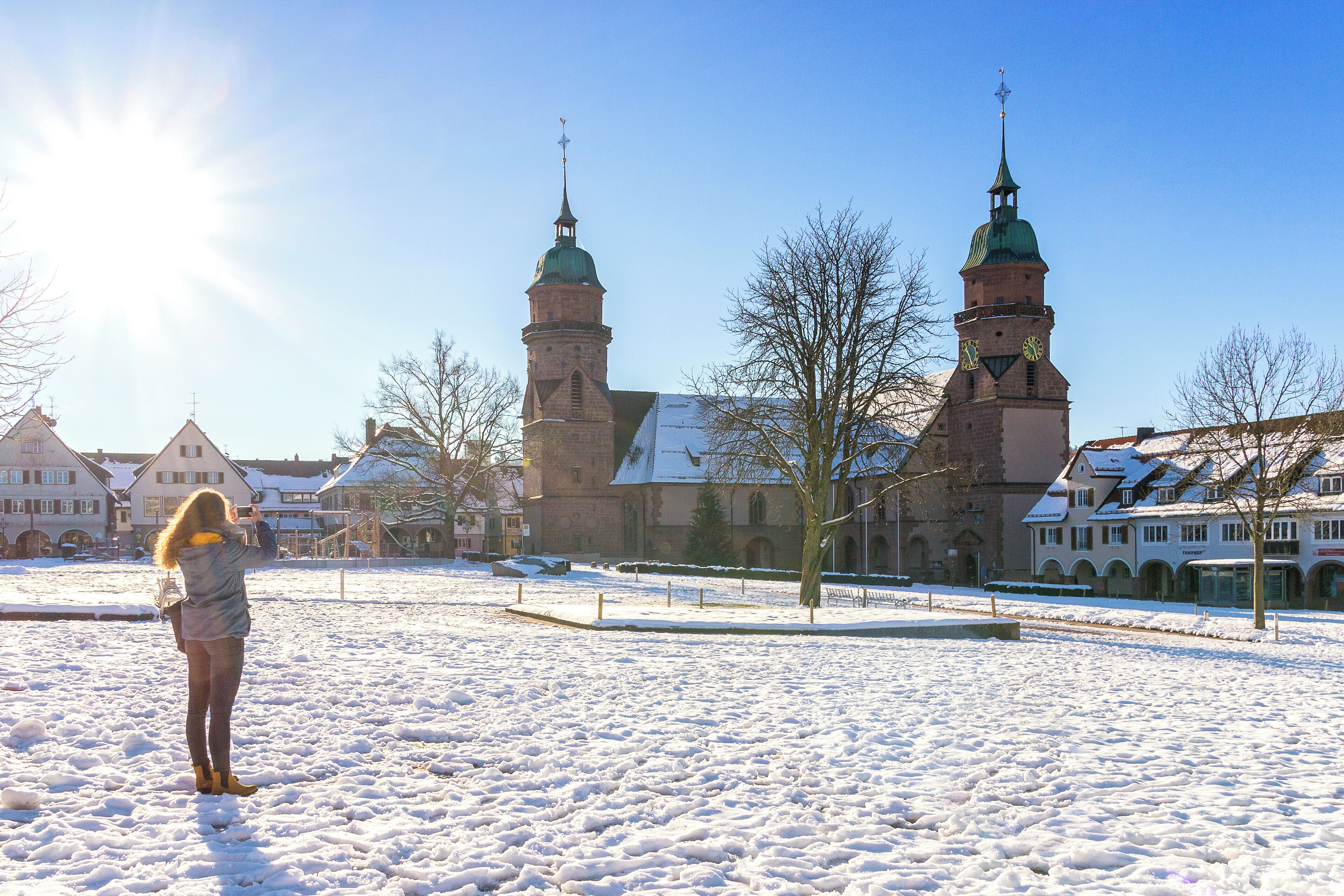 Et snedækket torv med en kirke og boligbygninger i baggrunden.