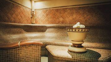 A spa area with a mosaic-tiled bench and a large ceramic basin.