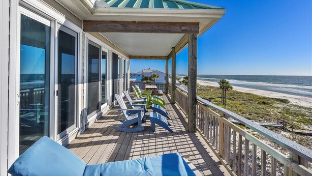 A wooden deck with lounge chairs and a view of the beach. - TRADEWINDS HAS LONG BEEN praised as a uniquely appointed home where treasured memories are made. (St. George Island)