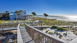 A beach house with a wooden deck and a view of the ocean. - TRADEWINDS HAS LONG BEEN praised as a uniquely appointed home where treasured memories are made. (St. George Island)