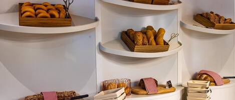 A bakery display with various breads and pastries on shelves.