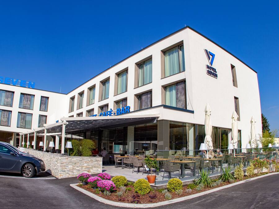Ein Hotel im modernen Stil mit Café-Bar im Erdgeschoss, Außenplätzen und einem gepflegten Garten.
