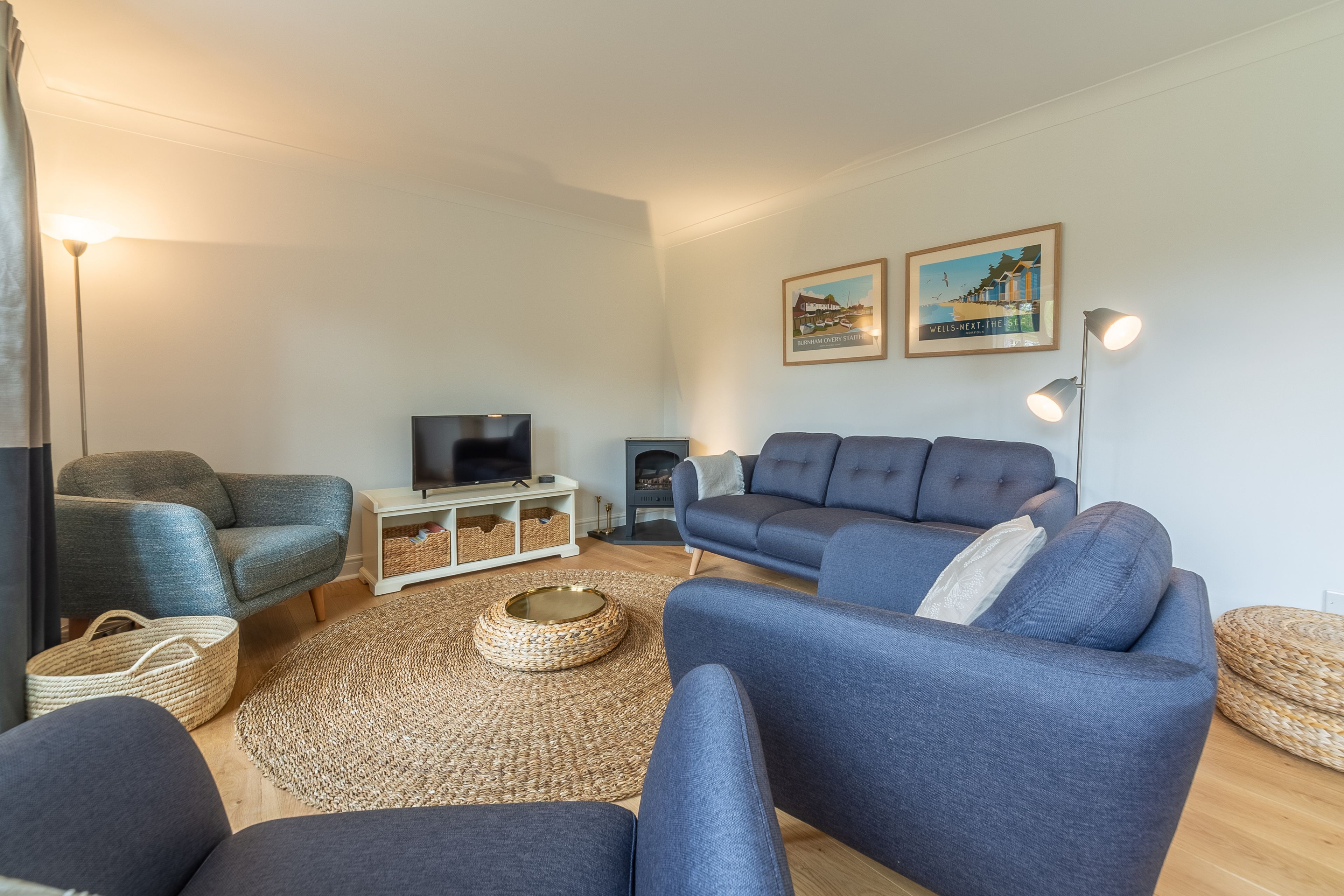 Una sala moderna con un conjunto de sofá, televisión y chimenea.