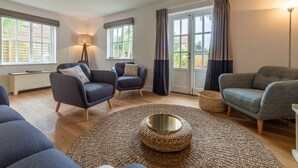 A modern living room with two sofas, a round coffee table, and a floor lamp.