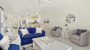 A living room with a blue sofa, grey armchairs, a coffee table, and a kitchen in the background. - 🏖️Ocean Views, Newly Renovated🏖️ (Ocean City)