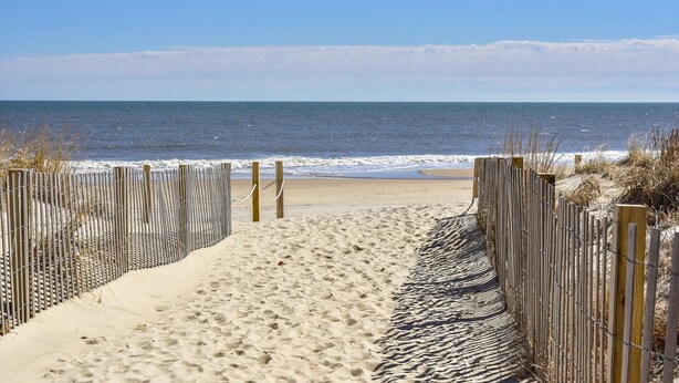 A sandy beach path leading to the ocean, bordered by wooden fences and some vegetation. - 🏖️Ocean Views, Newly Renovated🏖️ (Ocean City)