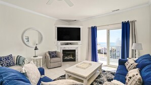 A living room with a fireplace, a television, and a balcony with curtains. - 🏖️Ocean Views, Newly Renovated🏖️ (Ocean City)