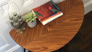 A round wooden table with a book and a small plant on it. - Spacious 2 bedroom -MIT, Harvard, Central Square with parking* (Cambridge)