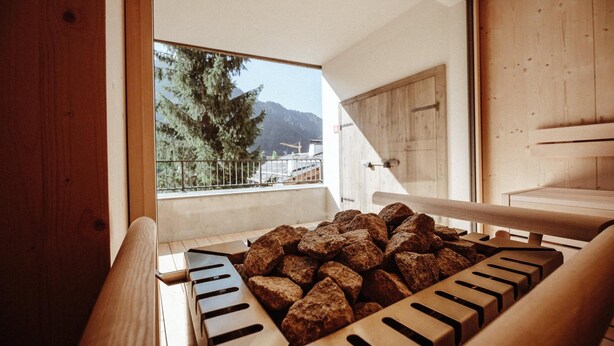A wooden interior with a large window overlooking a mountainous landscape. - Hotel Mea Via (Castelrotto)
