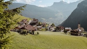 A mountain village with traditional buildings, a church, and a valley view. - Hotel Mea Via (Castelrotto)