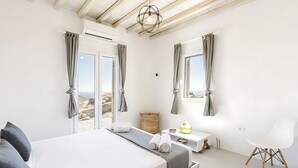 Un dormitorio moderno con cama, mesita de noche, una silla y vistas al exterior.