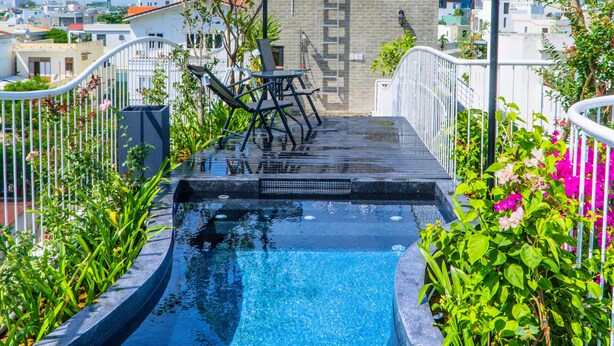 A rooftop pool with a view of the city skyline, surrounded by greenery and modern architecture. - Green Peace Da Nang (Da Nang)