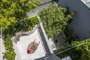 An aerial view of a courtyard with a bicycle, a red chair, and various plants. - Green Peace Da Nang (Da Nang)