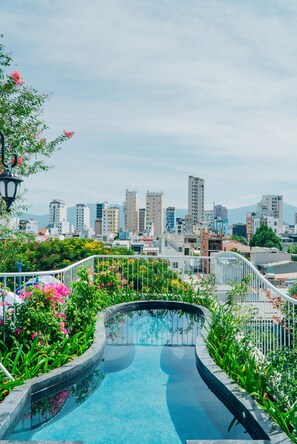 A rooftop pool with a cityscape view, surrounded by greenery and a white railing. - Green Peace Da Nang (Da Nang)
