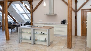 Una cocina moderna con vigas de madera, una isla central y un tragaluz.