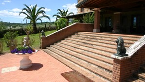 Un edificio de piedra con una escalera de ladrillo que conduce a un porche.