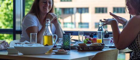 A dining table with breakfast items, a bottle of juice, and a pitcher.