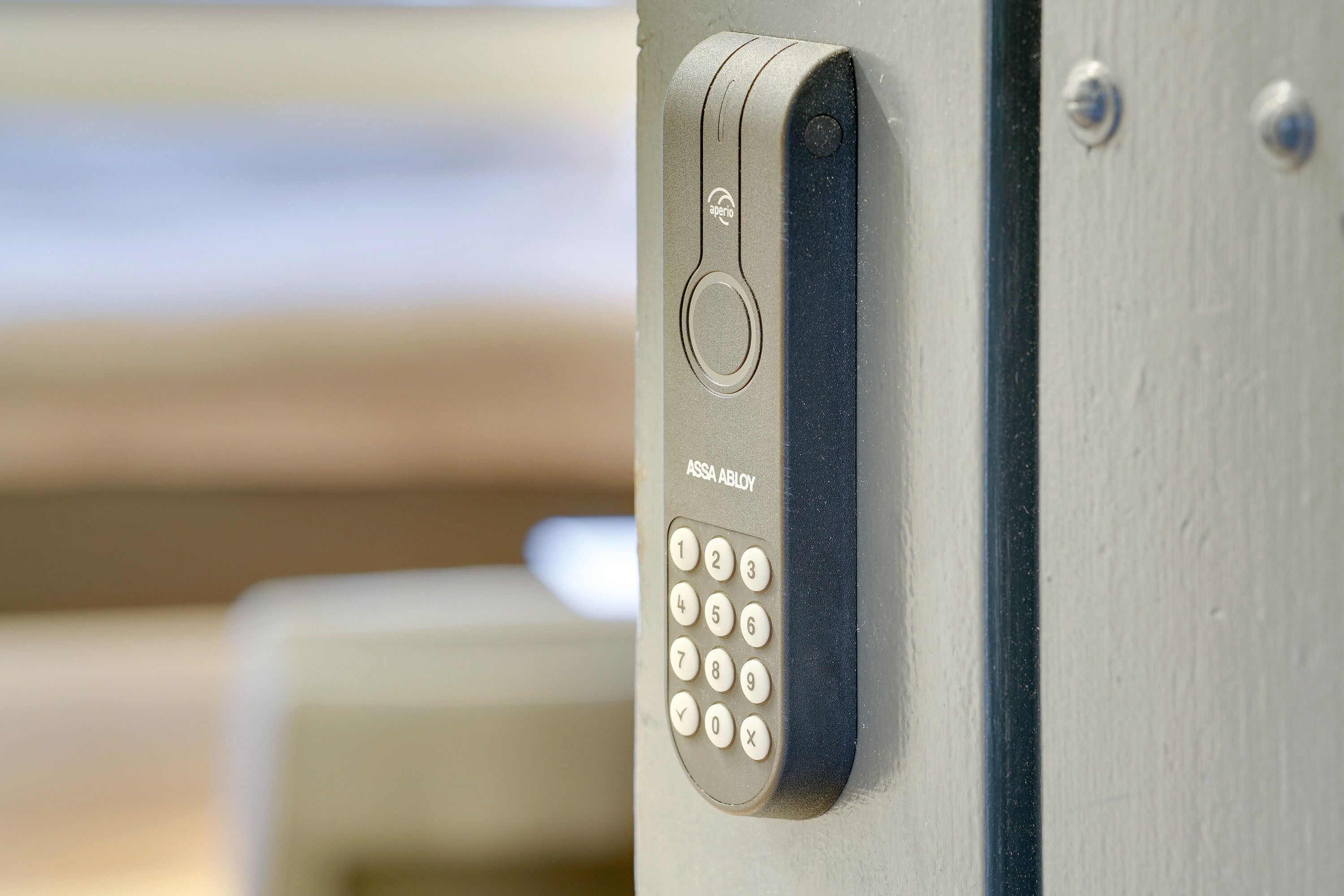Primer plano de un teclado de puerta con la etiqueta "ASSA ABLOY", que indica una característica de seguridad.
