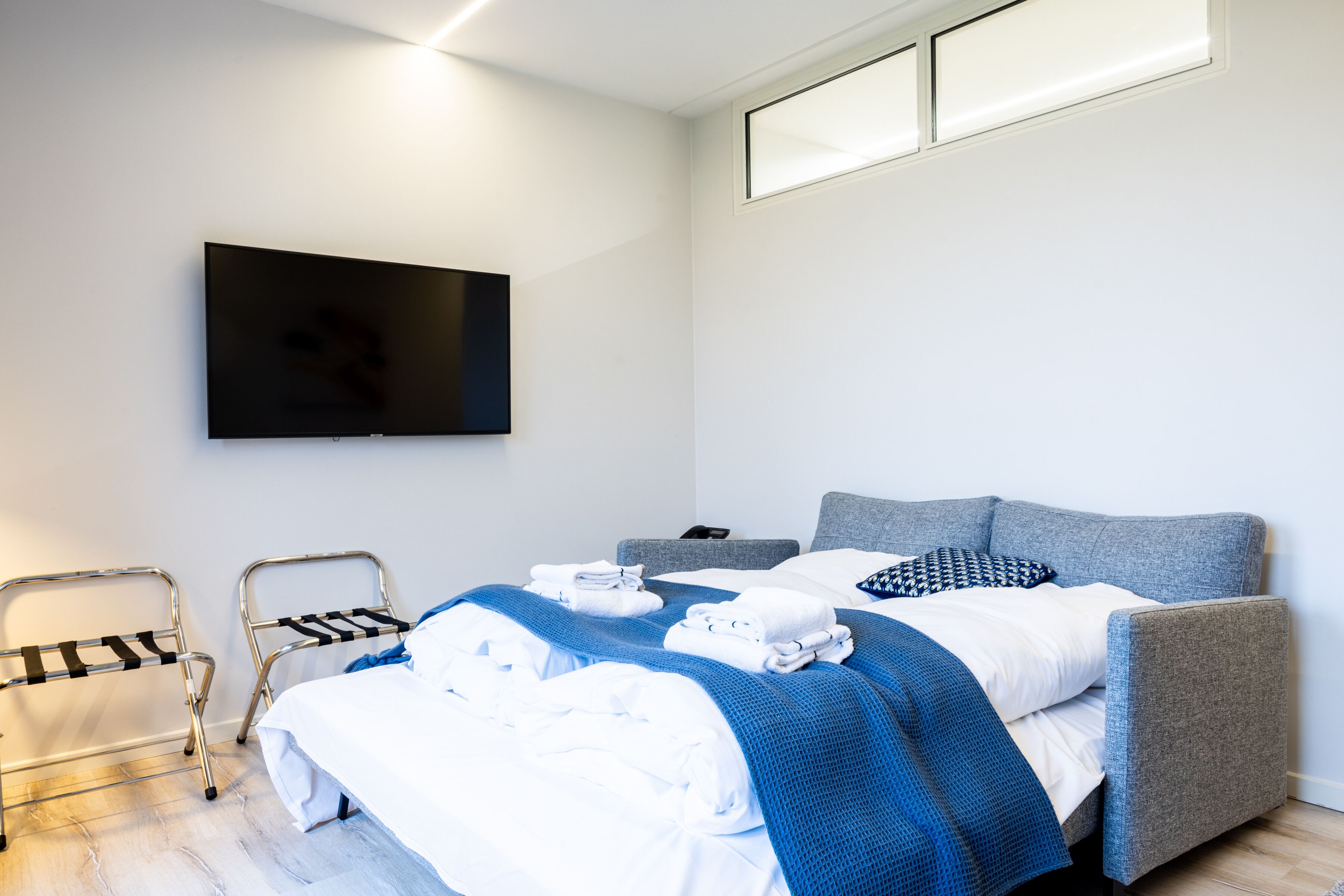 Une chambre d’hôtel moderne avec un lit, une télévision et une fenêtre.