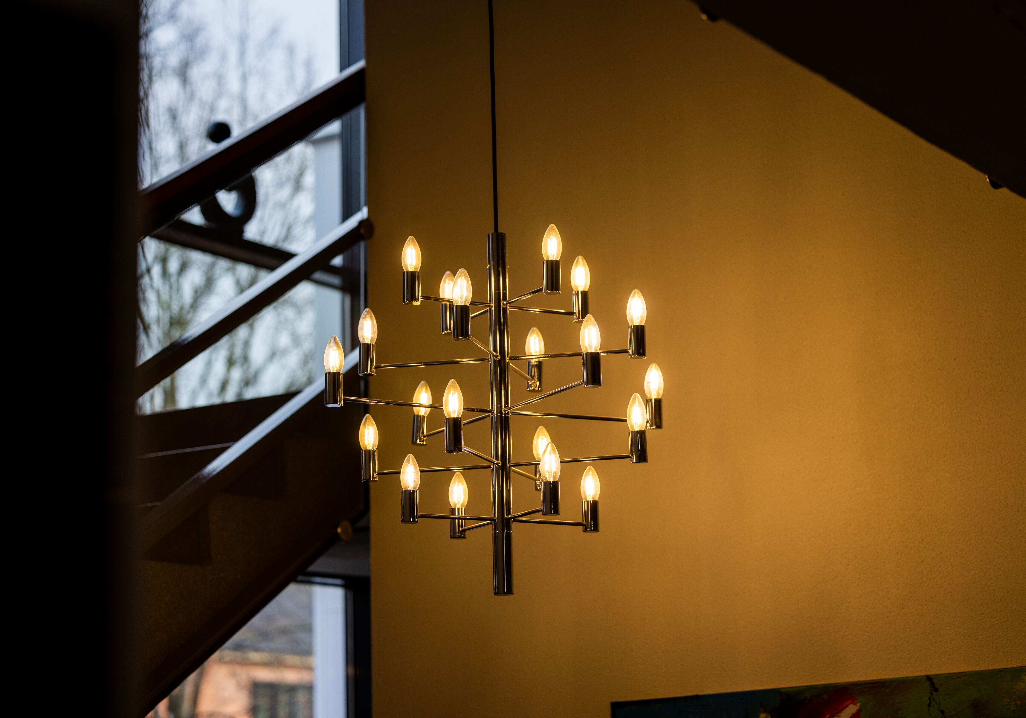 A chandelier with multiple bulbs hanging from a metal structure.