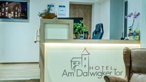 Een hotel receptie met een bord waarop staat 'HOTEL Am Dalwigker Tor'.
